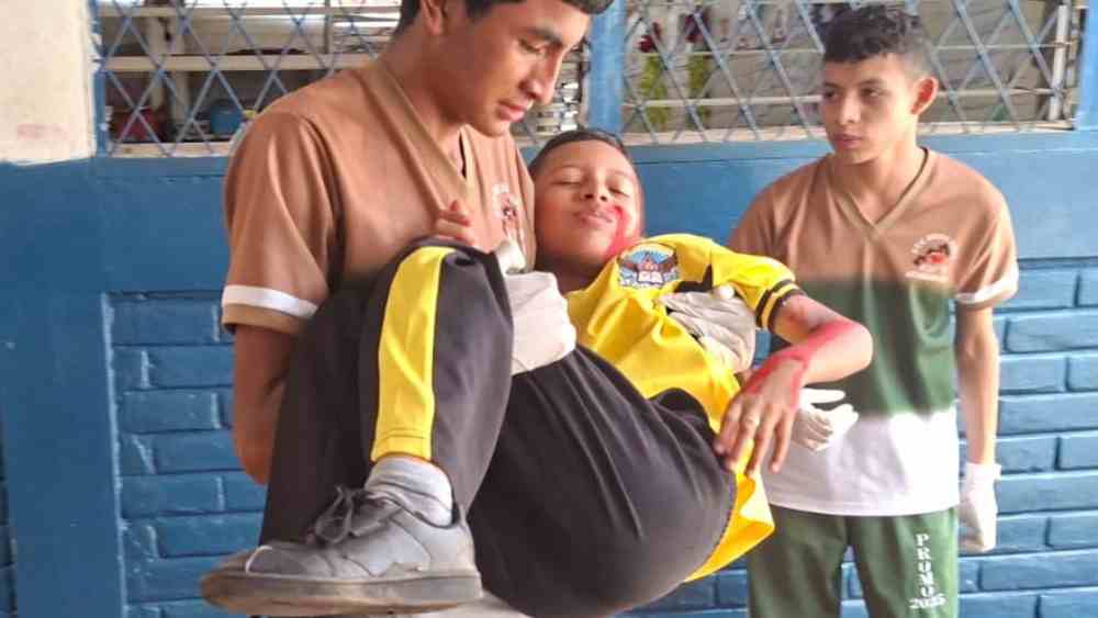 Voluntarios de Comandos de Salvamento atienden una simulación de fractura durante el simulacro en el Centro Cultural Salvadoreño, 21/10/2025.