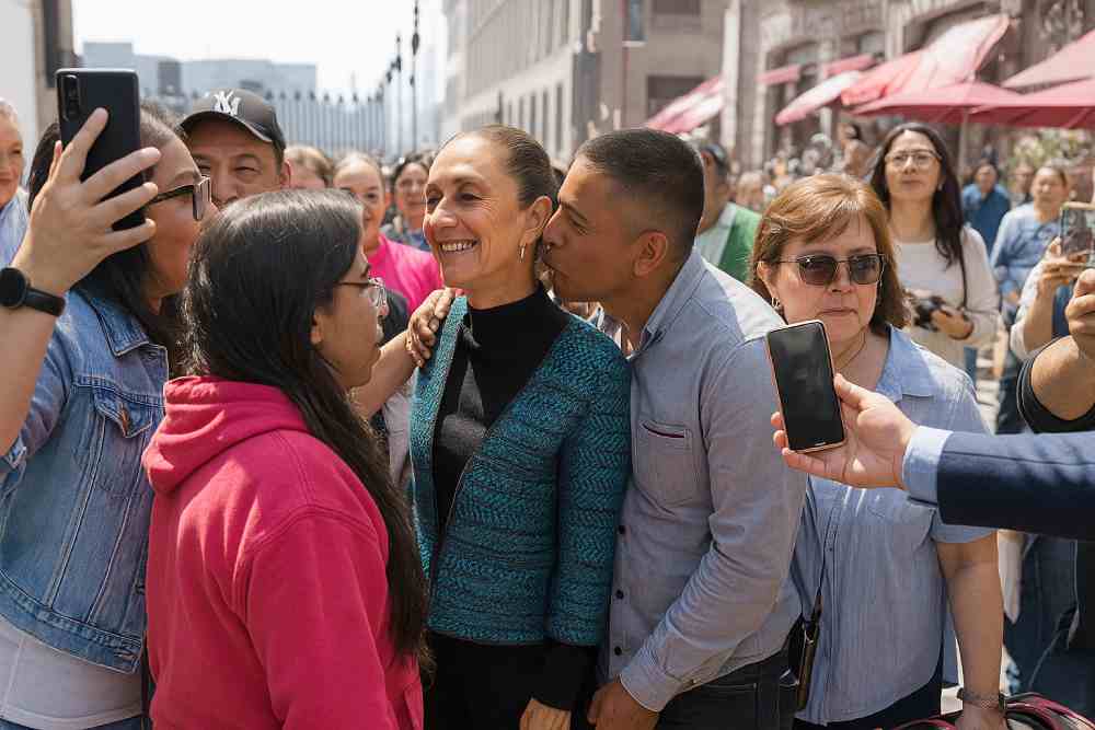 Imagen ilustrativa y reconstruida con inteligencia artificial a partir de un frame del video de baja calidad que circula en las redes sociales. La presidenta Claudia Sheinbaum fue víctima de un intento de beso no consentido en el Zócalo de la CDMX, lo que reavivó el debate sobre su seguridad.